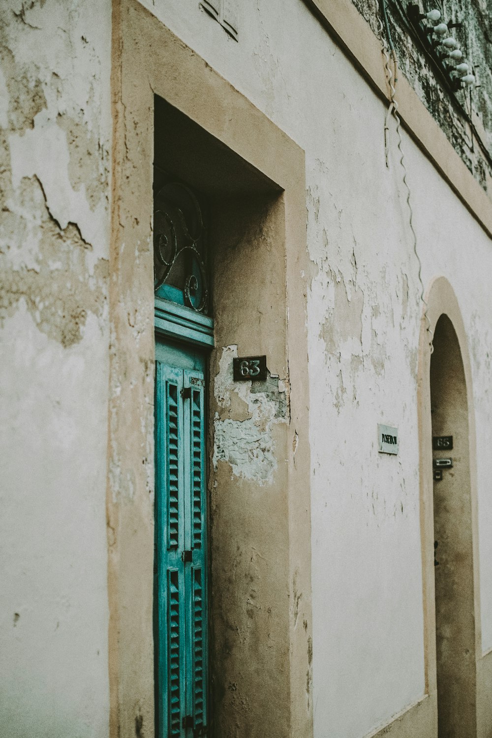 blue wooden door on white concrete building