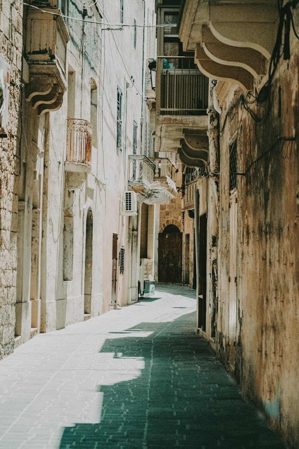 empty hallway between concrete buildings during daytime