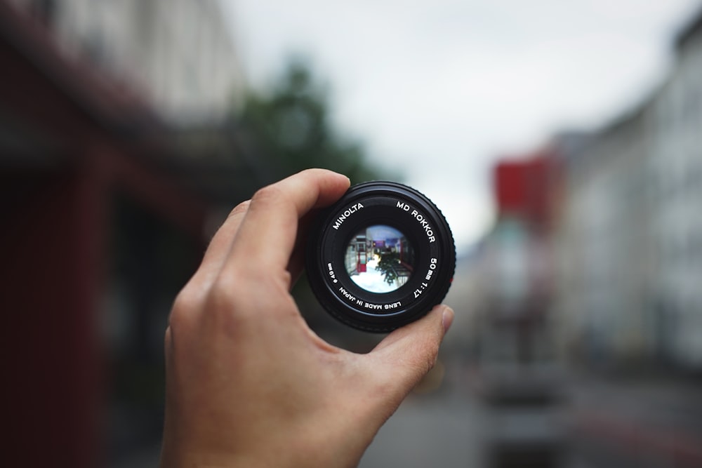 person holding black camera lens