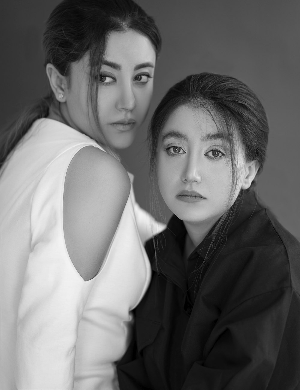 two women are posing for a black and white photo
