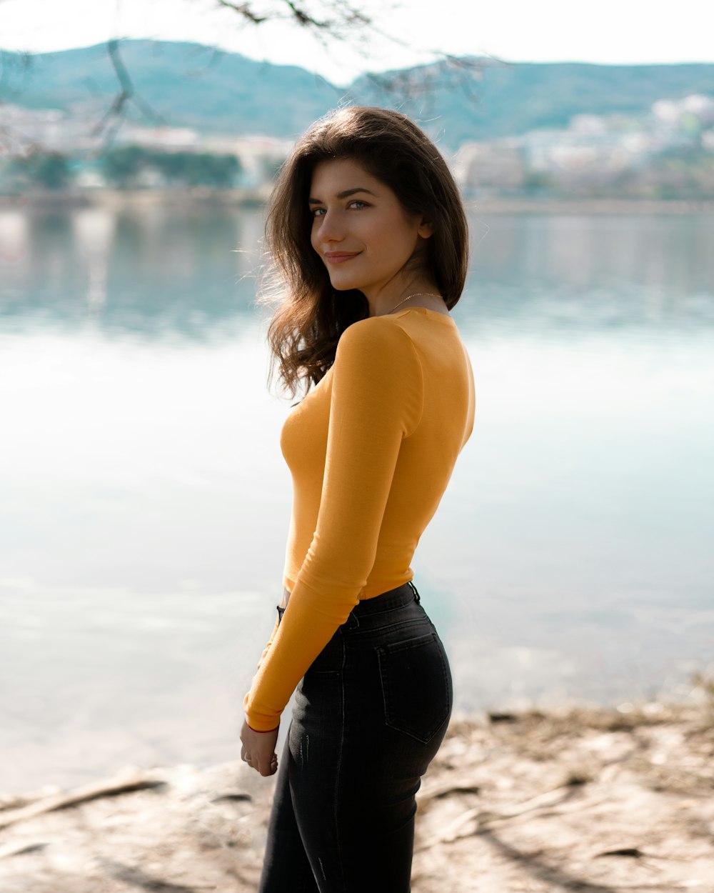 woman in yellow long sleeve shirt and black pants standing on beach during daytime