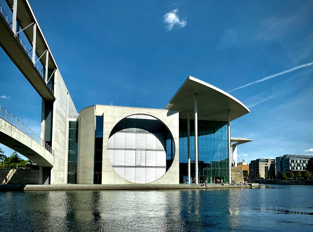 edificio in cemento bianco e grigio vicino allo specchio d'acqua durante il giorno