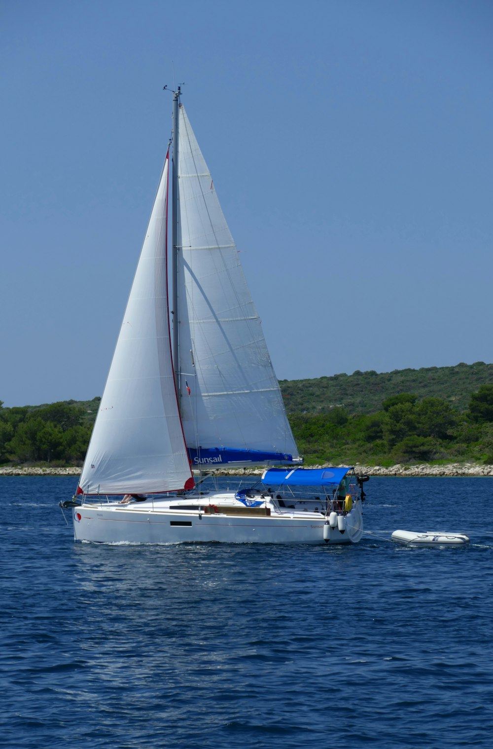 white sail boat on sea during daytime