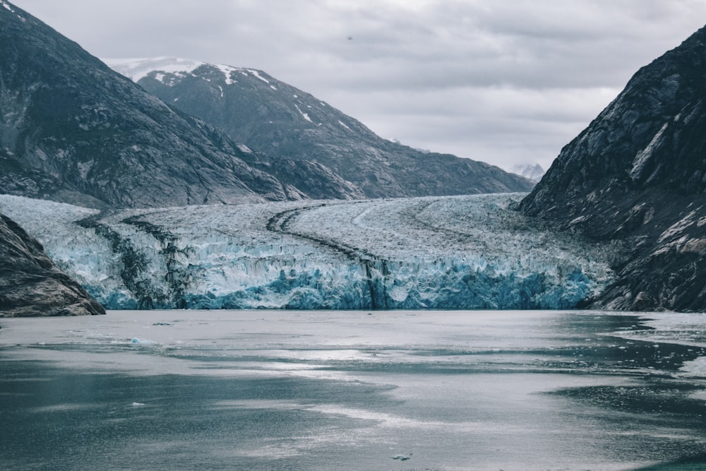 snow covered mountain near body of water