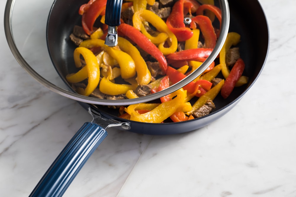 black ceramic bowl with sliced carrots and potatoes