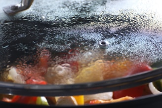 Close-up of a smart, transparent cooking pot with digital controls integrated on its surface.