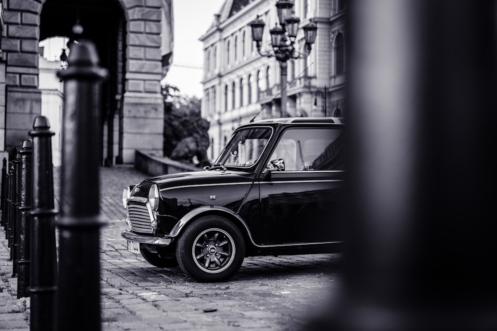 Foto en escala de grises de un coche en la calle