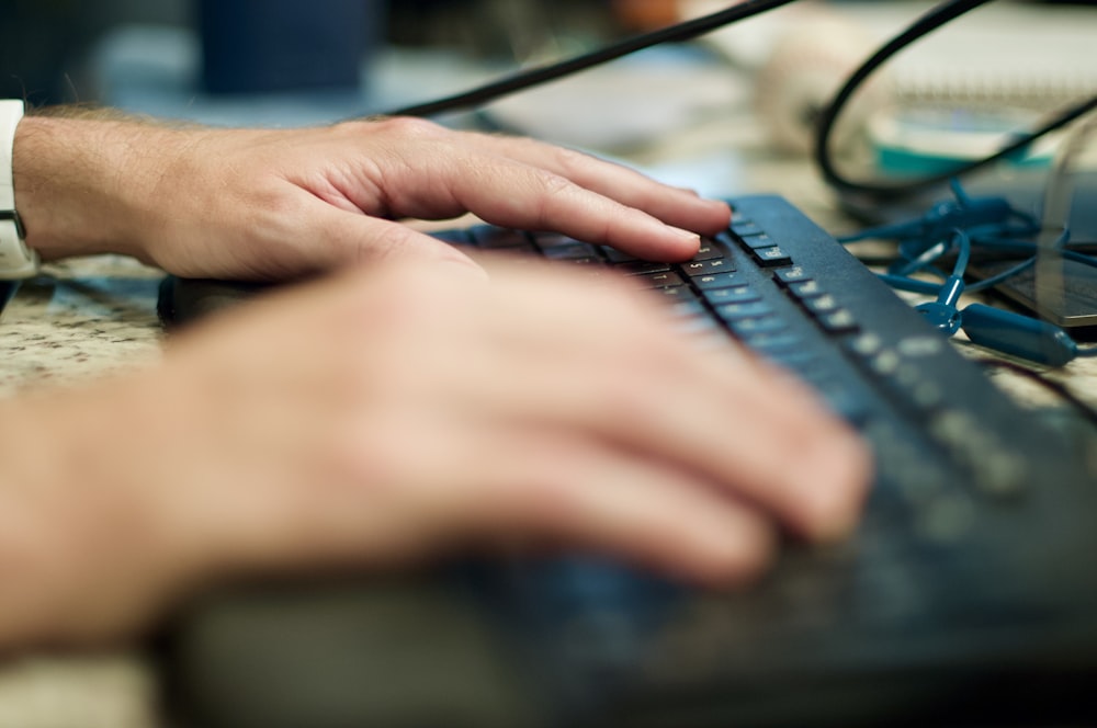 person using black computer keyboard