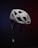 A white bicycle helmet is suspended in mid-air against a dark, gradient background, which transitions from blue to red. The helmet features several large ventilation holes and an adjustable chin strap. The brand name 'SMITH' is visible on the side.