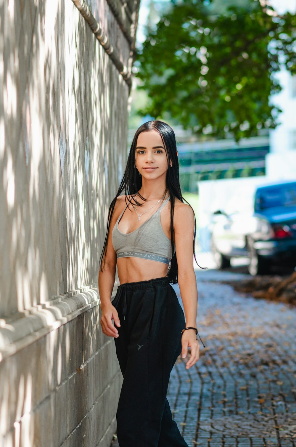 a woman standing next to a brick wall