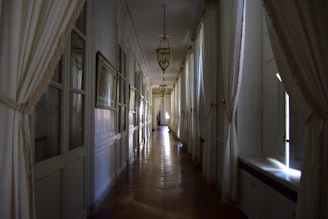 Elegant mansion hallway showcasing newly installed polished wooden floors with soft lighting.