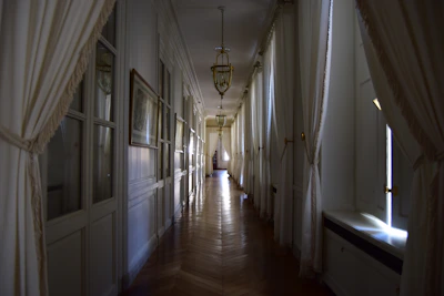 Elegant mansion hallway showcasing newly installed polished wooden floors with soft lighting.