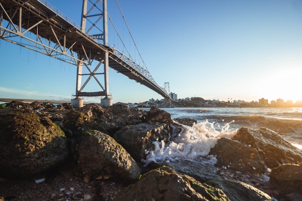 gray metal bridge over the sea during daytime