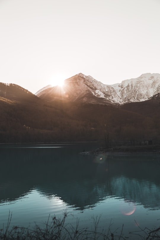 green lake near brown mountain during daytime in Aviano Italy