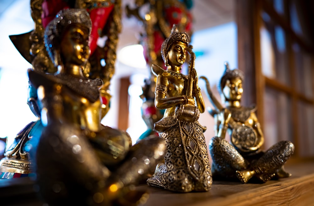 a group of gold figurines sitting on top of a wooden table