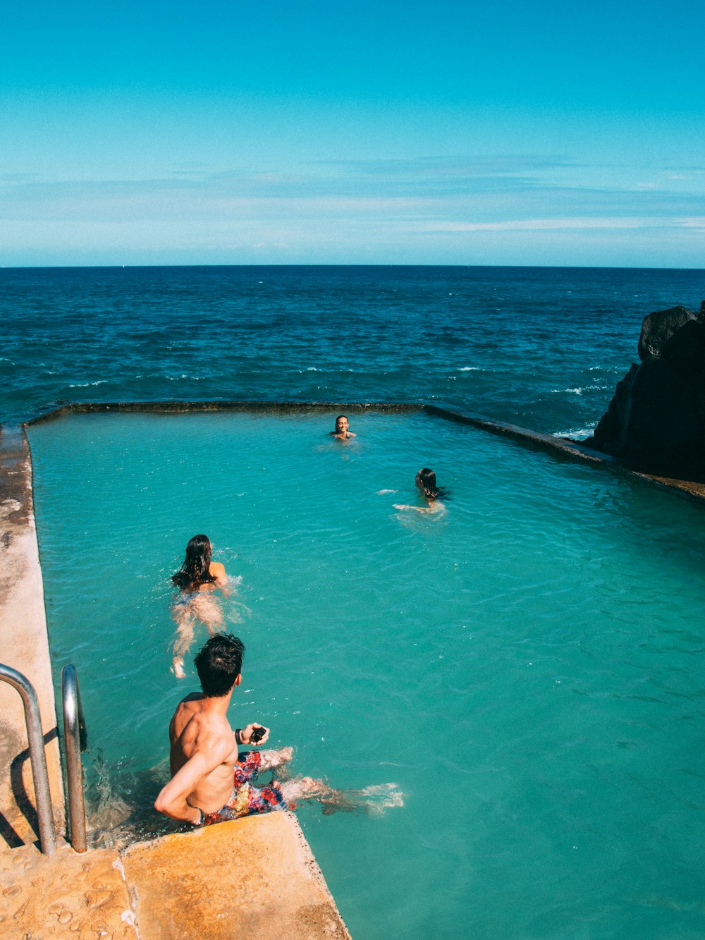 people swimming in the sea during daytime