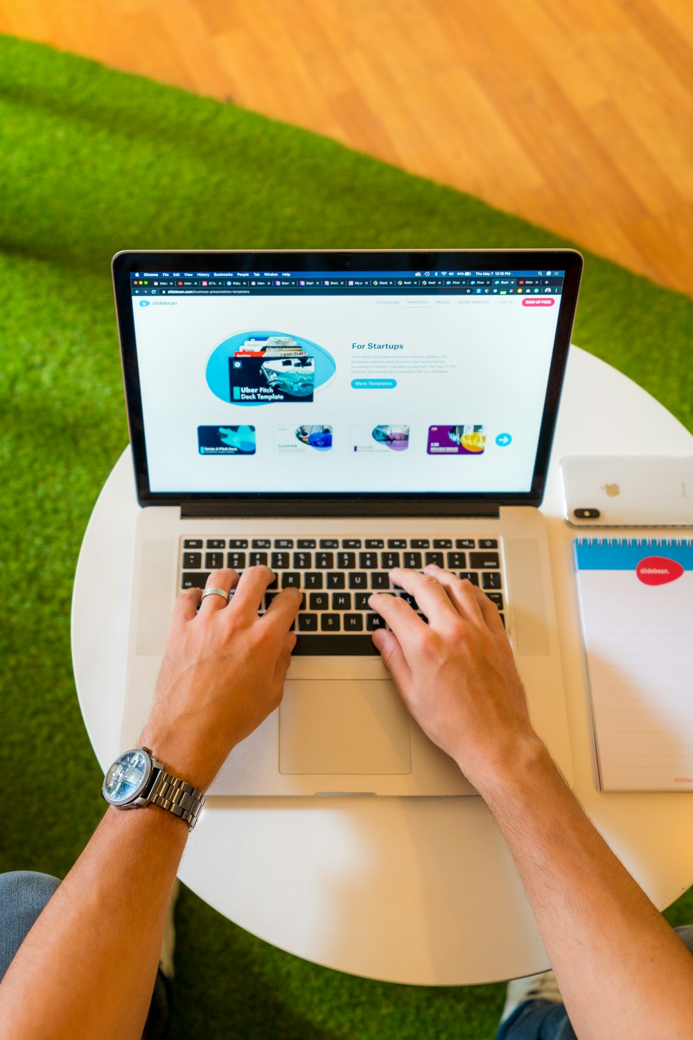 person using macbook pro on white table