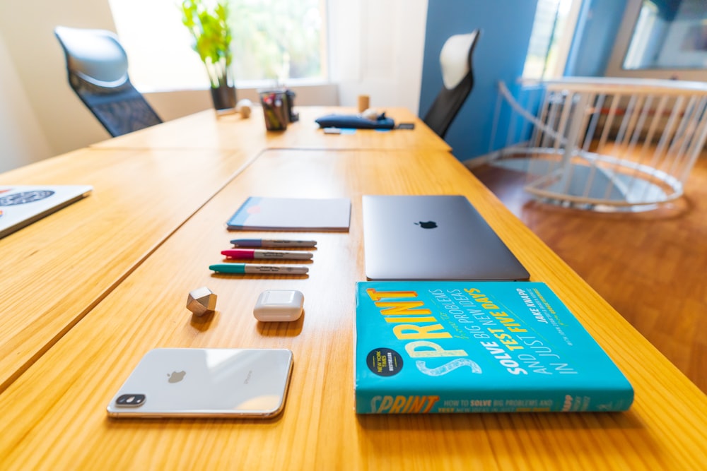 silver macbook on brown wooden table