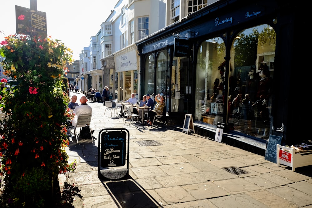 people sitting on white plastic chairs near building during daytime