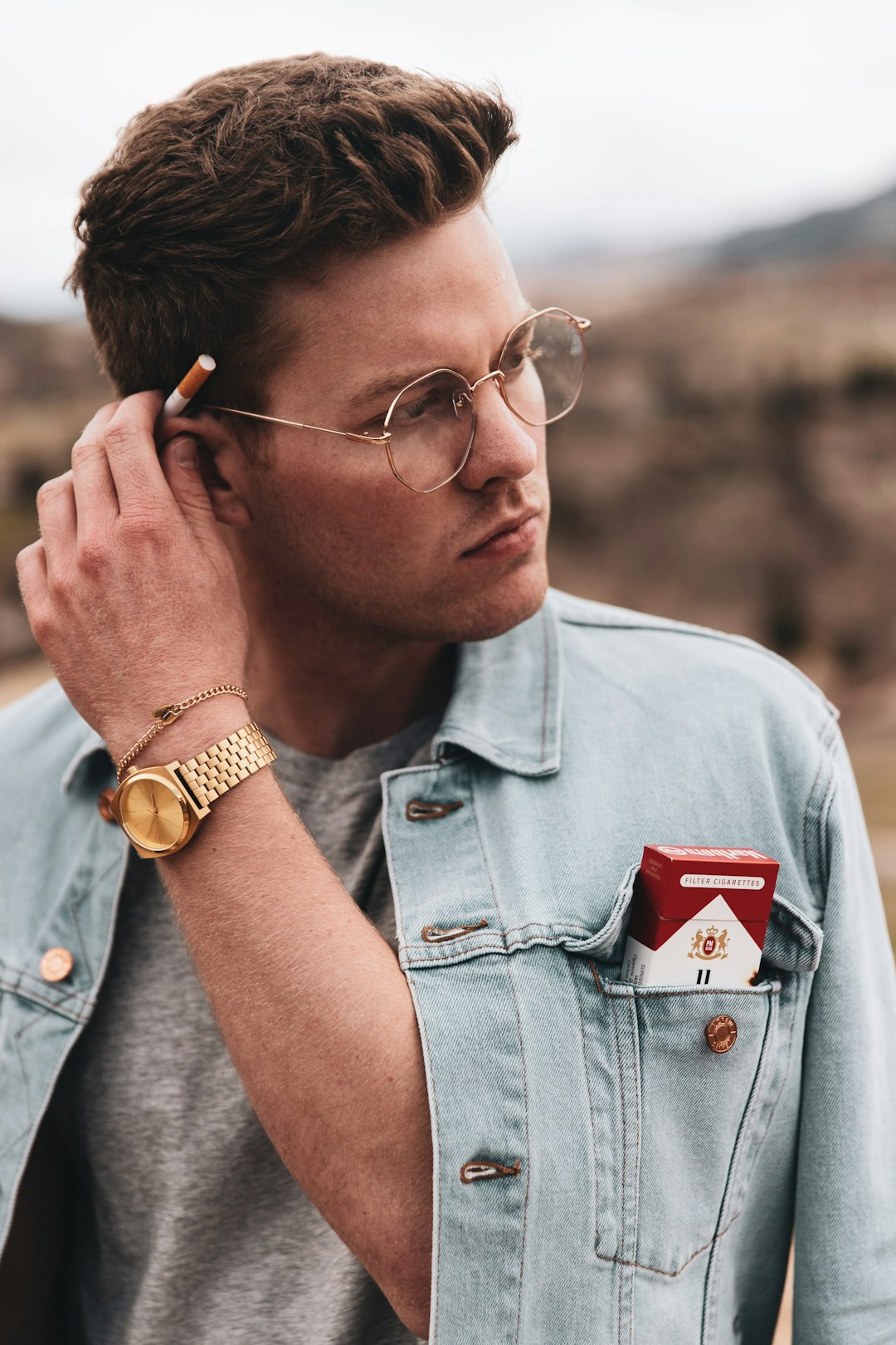 man in blue button up shirt wearing gold round analog watch