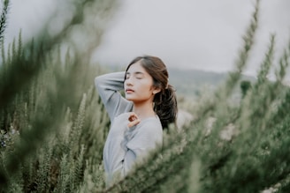 Soft focus of a person meditating surrounded by aromatic plants.