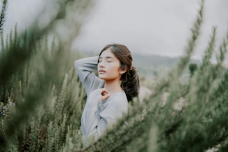 A serene person practicing deep breathing surrounded by soft natural light and greenery.