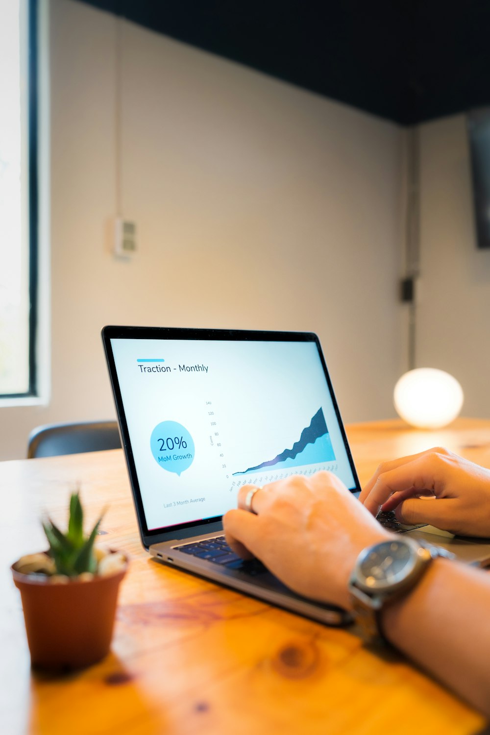 Personne utilisant un MacBook Pro sur une table en bois marron