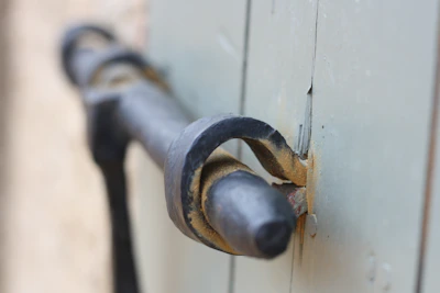 Close-up of a rustic metal door handle on a reclaimed wood door.