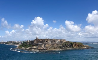 people standing on rock formation near sea under blue sky during daytime