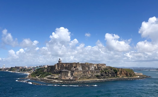 people standing on rock formation near sea under blue sky during daytime