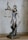 A bronze sculpture of Lady Justice, depicted with a blindfold, holding scales in one hand and a sword in the other. The figure stands on a detailed base featuring a snake and other ornate elements.
