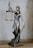 A bronze sculpture of Lady Justice, depicted with a blindfold, holding scales in one hand and a sword in the other. The figure stands on a detailed base featuring a snake and other ornate elements.