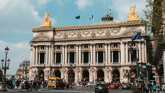 cars parked in front of white concrete building during daytime in Palais Garnier France