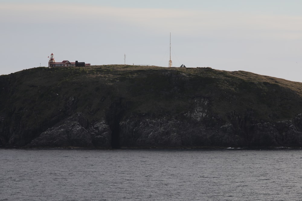 white and brown lighthouse on top of hill by the sea