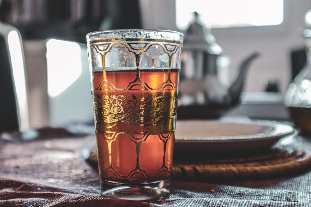 clear drinking glass with brown liquid