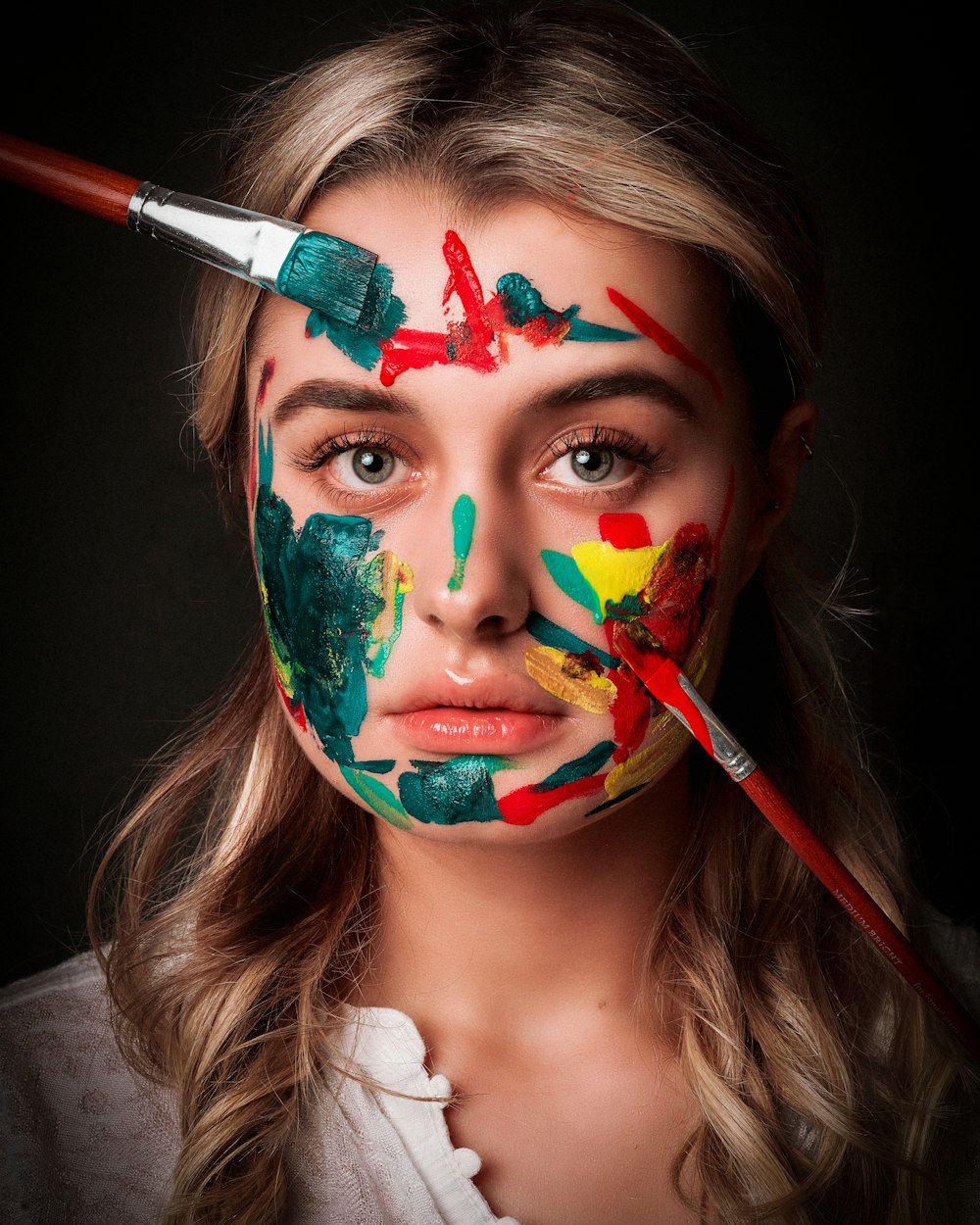 femme avec de la peinture faciale rouge, verte et jaune