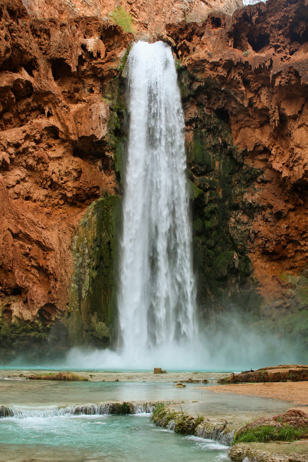 waterfalls on brown rocky mountain during daytime