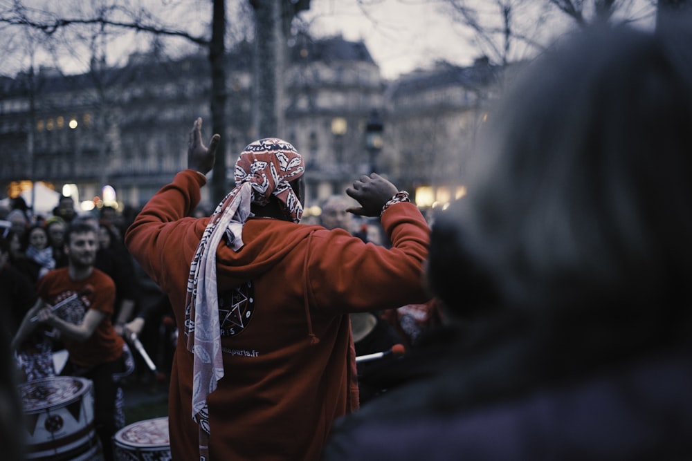 man in red hoodie standing on snow covered ground during daytime