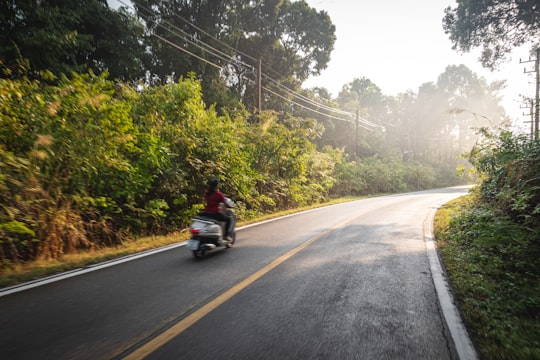 man in black jacket riding motorcycle on road during daytime in Koh Chang Thailand