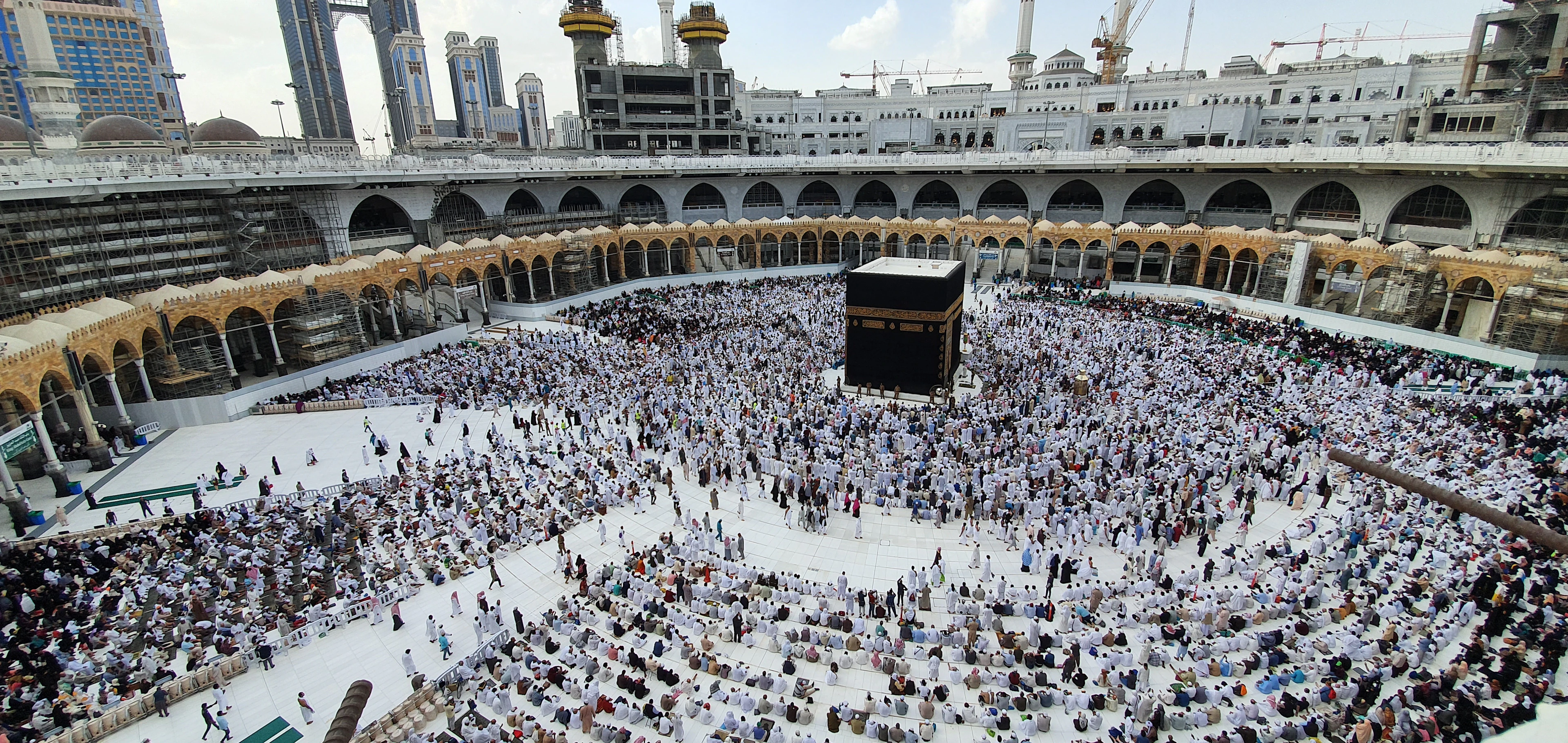 A wide view of the courtyard of Masjid al-Haram filled with pilgrims