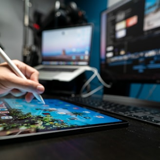 person holding pen in front of black laptop computer