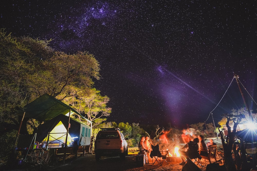 people gathering around bonfire during night time