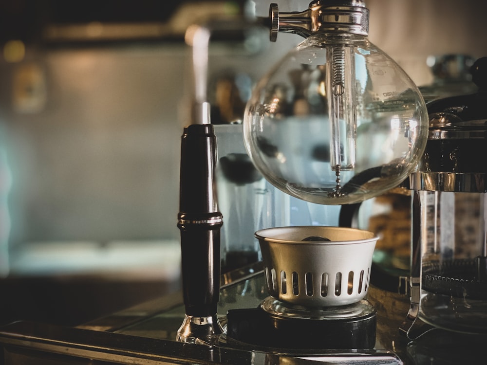 black and silver coffee maker beside white ceramic cup