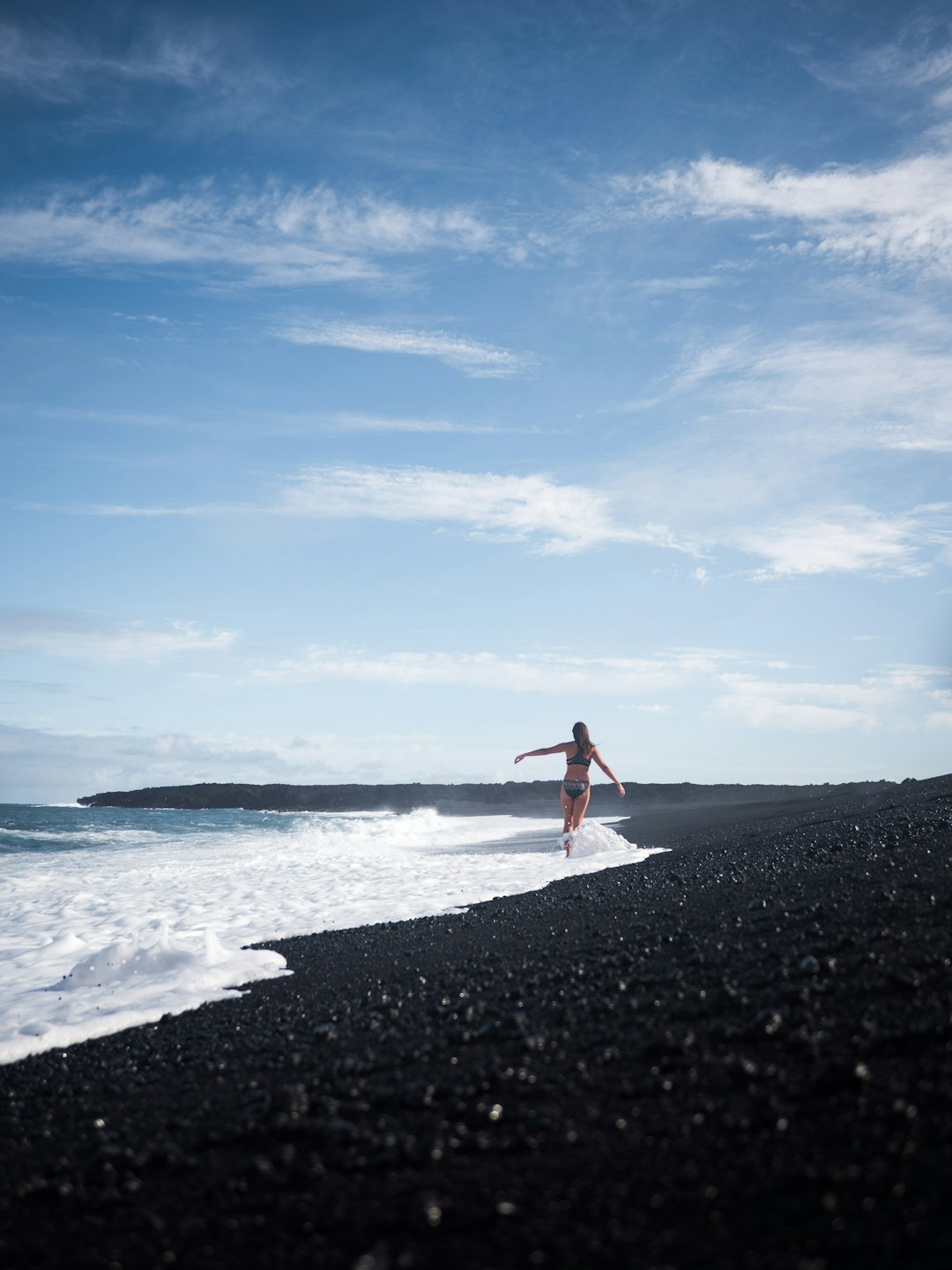 woman in red dress standing on beach during daytime