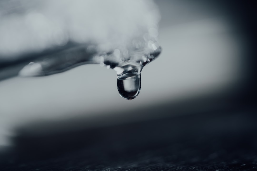 water drop in grayscale photography