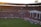A crowded football stadium filled with passionate fans, many wearing red, celebrating and supporting their team with banners and flags. The atmosphere is lively, with a match taking place on the field, and the stadium is decorated with various colorful signs and banners.