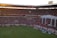 A passionate Flamengo fan cheering in a crowded stadium wearing red and black.