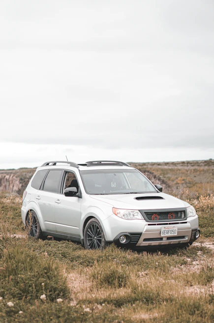 Silver SUV with roof rack, ready for weekend adventures on a country road