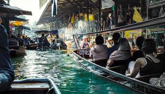 people riding on boat during daytime in Damnoen Floating Market Thailand