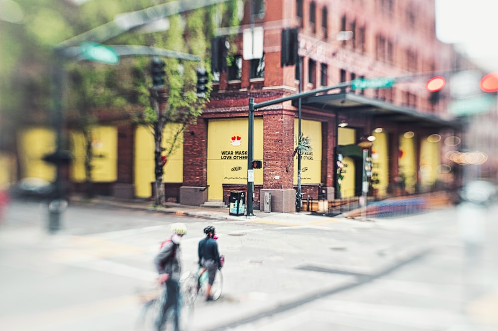 people walking on sidewalk near brown building during daytime